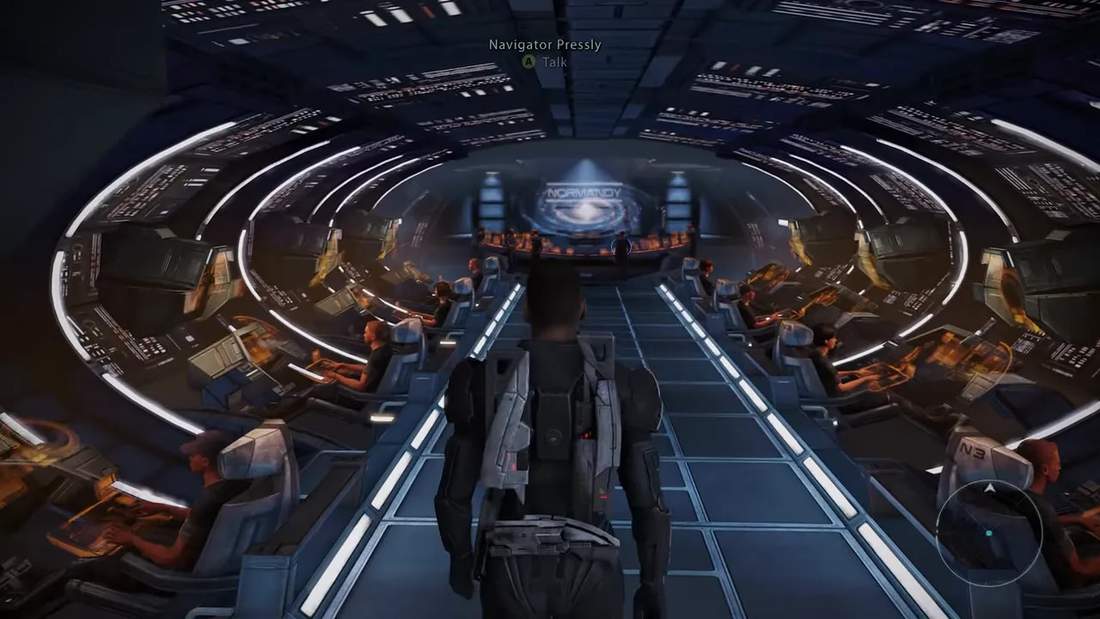 Third‑person view of Commander walking down the Normandy corridor toward the bridge with crew at consoles