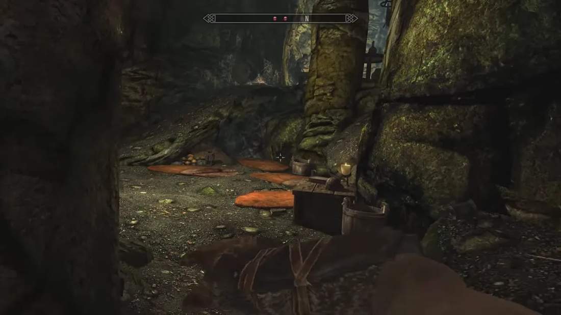 Skyrim cave interior with loot containers and lantern light during exploration