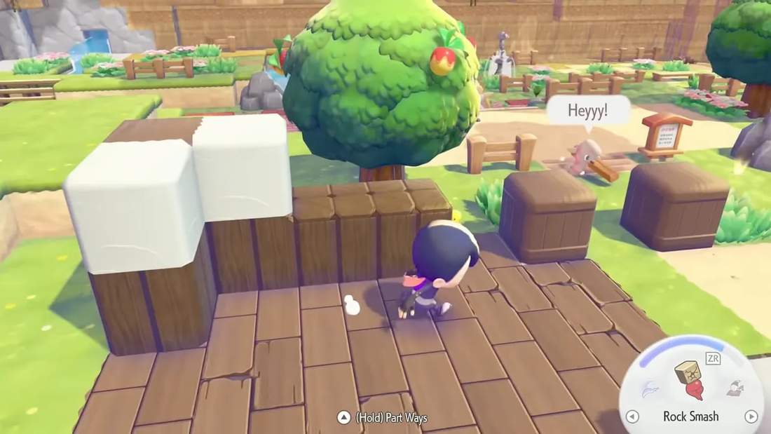 Player running across wooden tiles with raised blocks and a tree, demonstrating modified terrain in Pokopia.