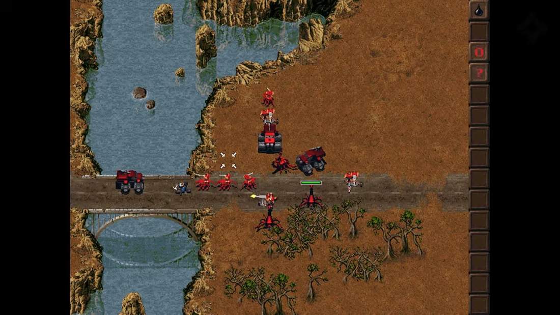 KKND gameplay screenshot with multiple units and vehicles near water and terrain features