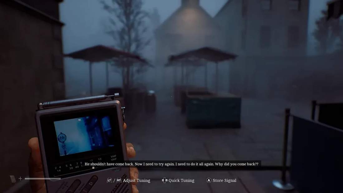 Portable CCTV device held in a foggy outdoor courtyard with umbrellas and buildings