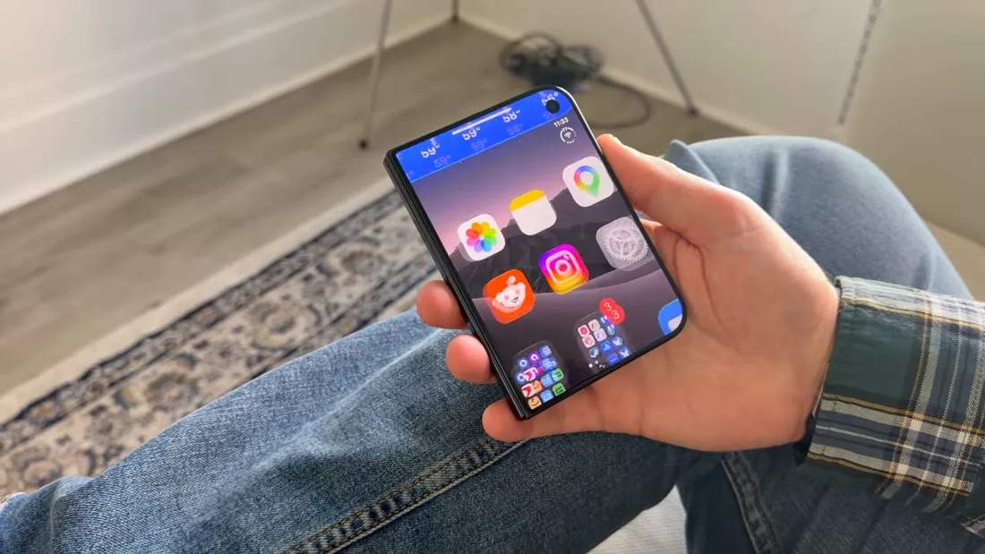 Folded phone held in one hand with app icons on its front screen